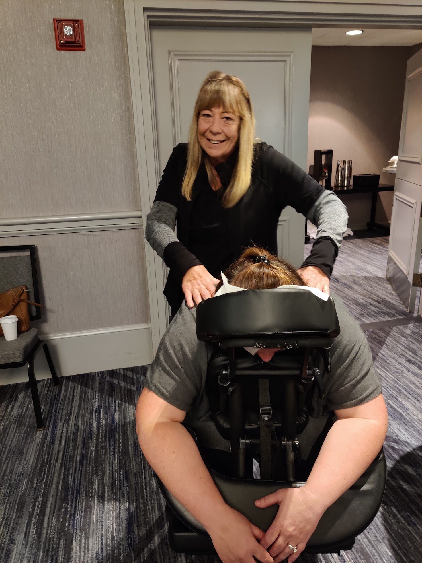 Massage by Design therapist providing onsite chair massage at a Chicago corporate conference event