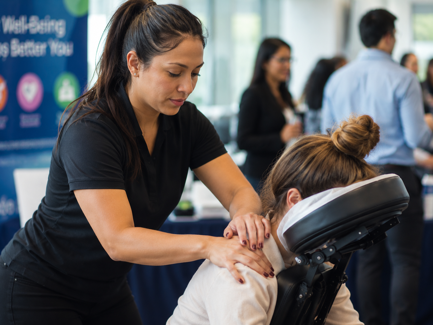 Close-up of licensed massage therapist providing onsite chair massage at a corporate health fair
