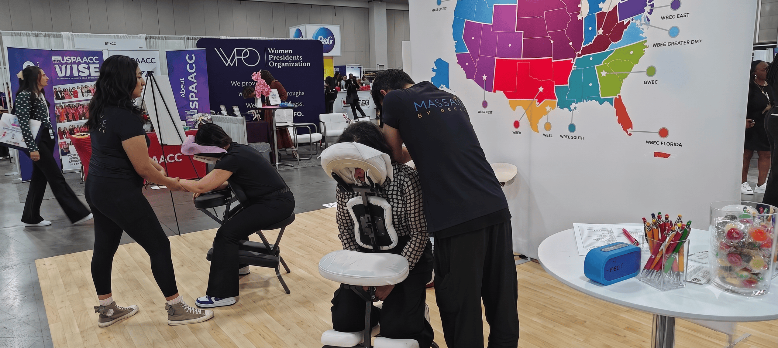 Massage by Design massage therapists providing onsite chair massage at a corporate conference